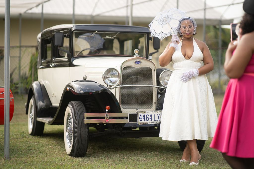Guests posing with a classic car at the Vintage Picnic in the Park