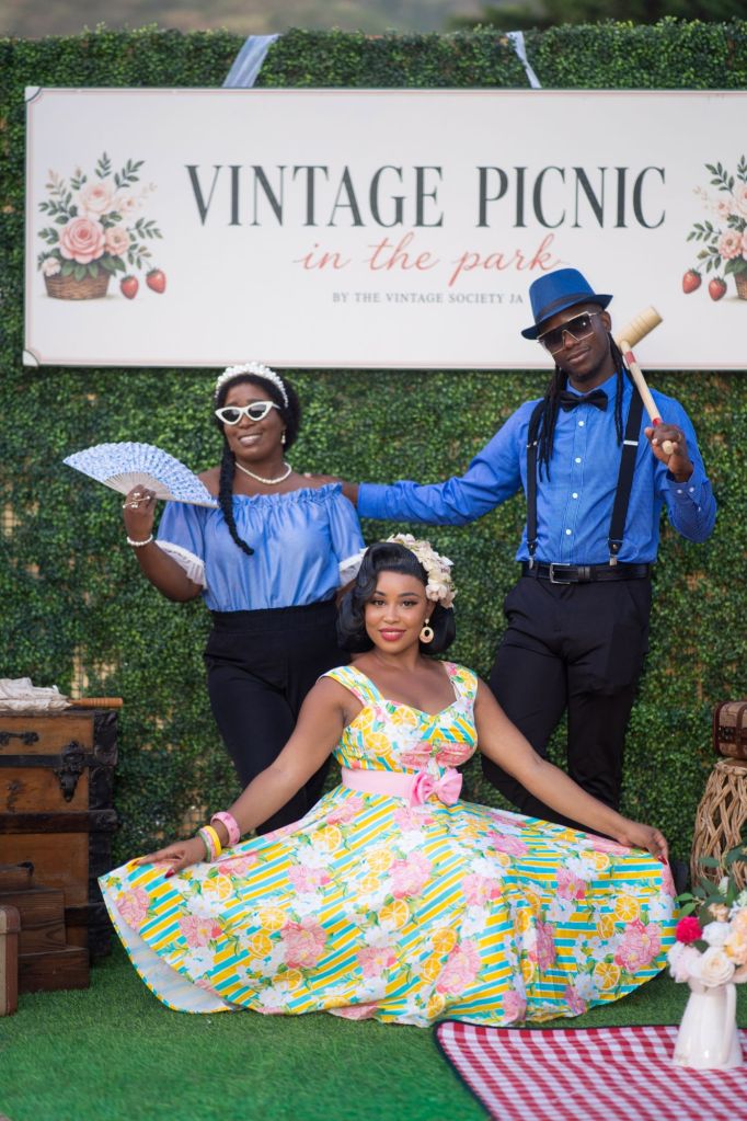 Guests posing beneath the Vintage Picnic in the Park sign