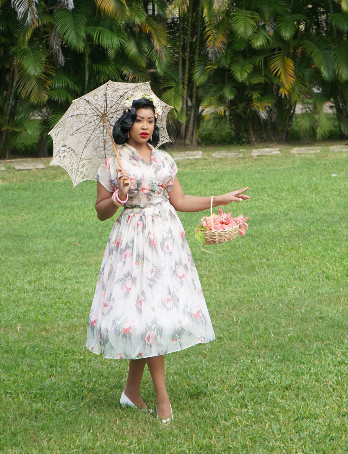 Lady E in a floral dress holding a lace parasol
